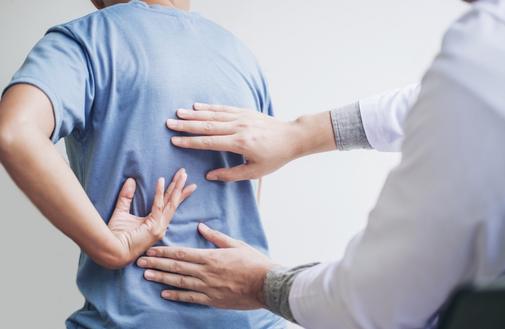 A doctor examining a patient's back